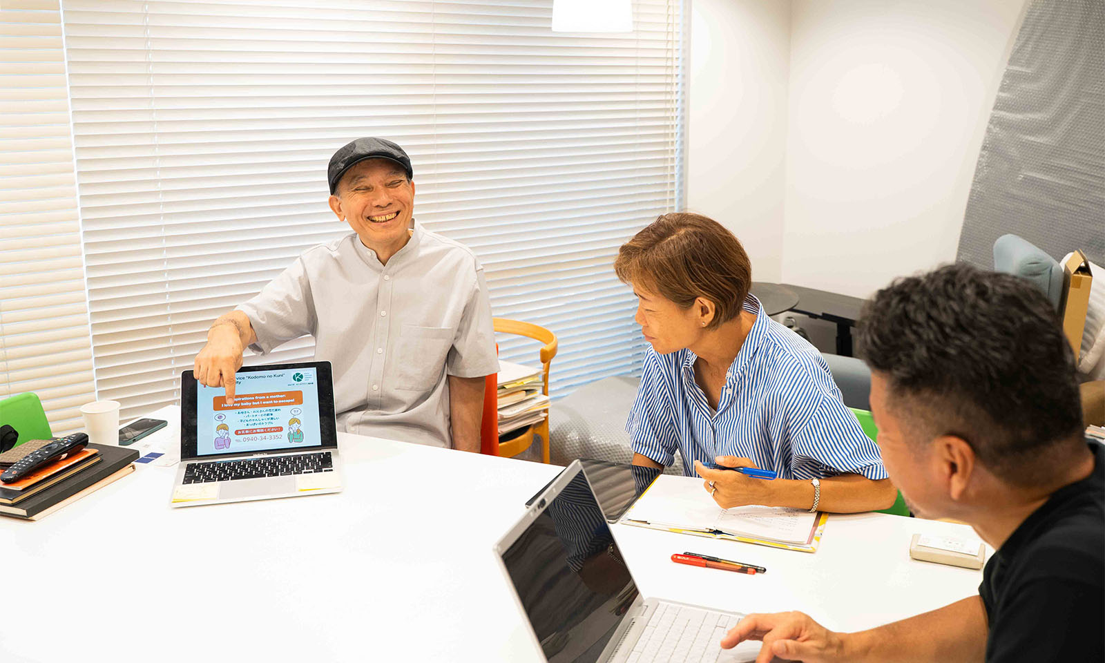 ALTはじまり。研究室の中心に置かれた白くて大きな正方形の机。その周りに着席する３人。平井先生がご自身のパソコンを開き指を挿しながら満面の笑顔で説明をされ、それを笑顔で頷きながら聞くコクヨのお二人。ALTおわり。