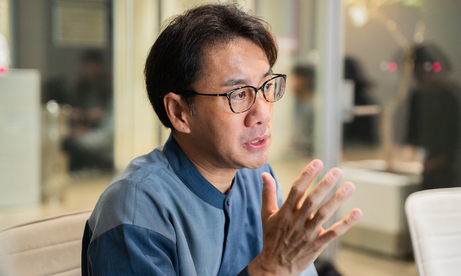 ALTはじまり。ガラス張りの会議室でインタビューに応える丹野さん。右手を上げながら冷静に質問に答えている。ALTおわり。