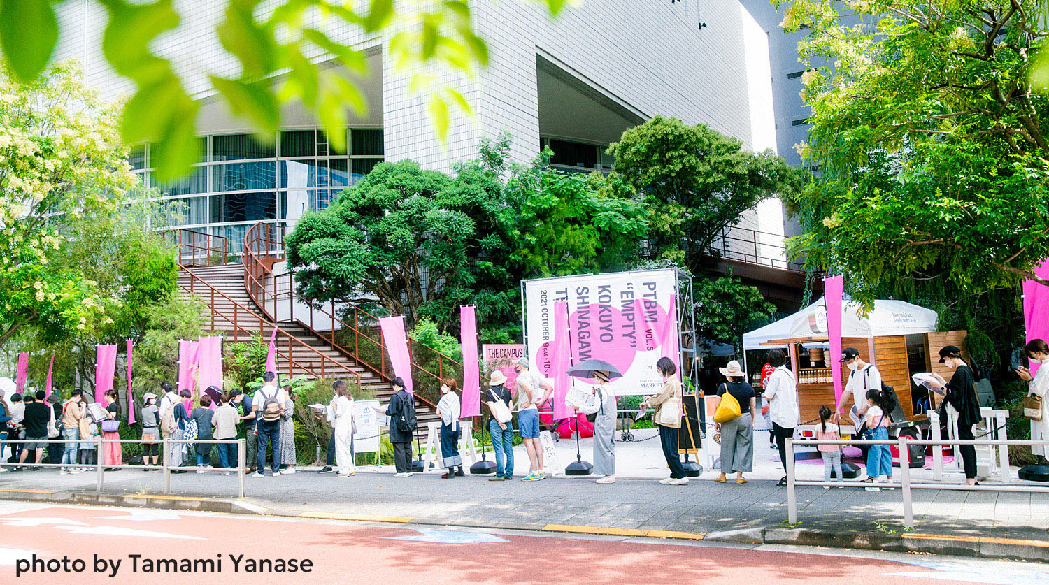 コクヨ品川オフィスの前にピンク色ののぼりがはためく。パスザバトンマーケットのオープンに向けて並ぶ人々。