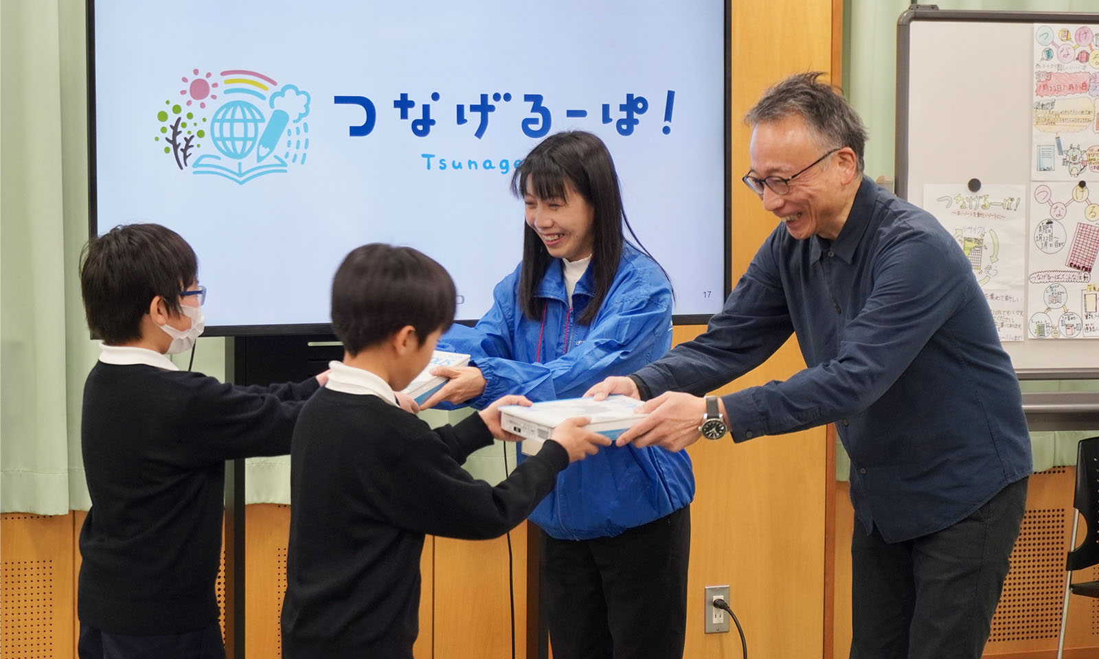 つなげるーぱ!を子どもたちに贈呈している画像