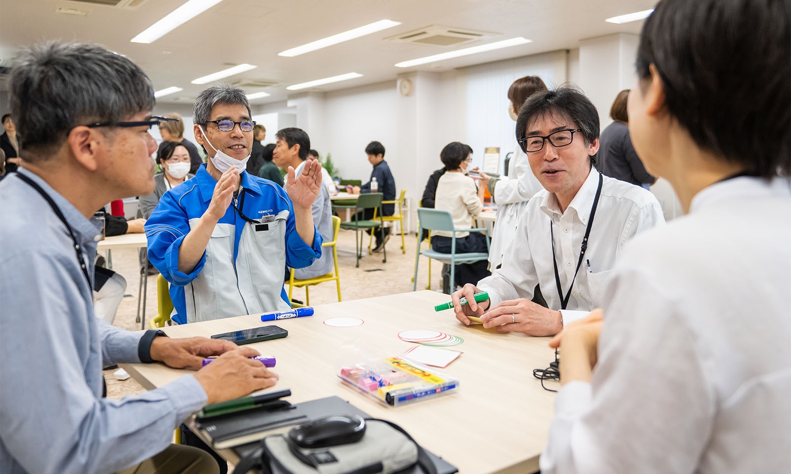 4人の人がテーブルを囲んで対話する様子