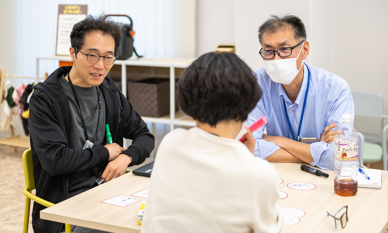3人の人がテーブルを囲んで対話する様子